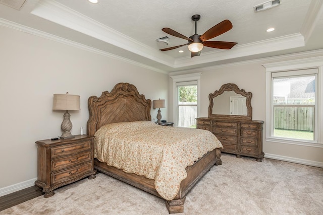 bedroom with a raised ceiling, ceiling fan, and ornamental molding