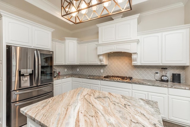 kitchen featuring light stone countertops, crown molding, white cabinets, and stainless steel appliances