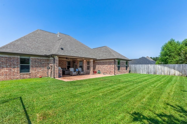 rear view of house with a yard and a patio