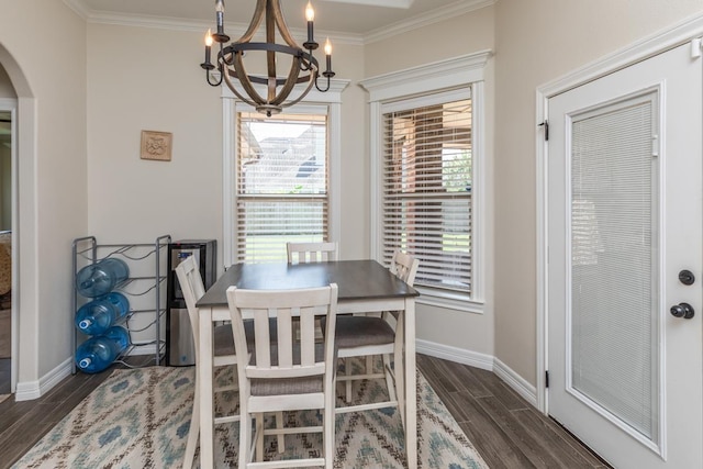 dining room with dark hardwood / wood-style flooring, a notable chandelier, and ornamental molding