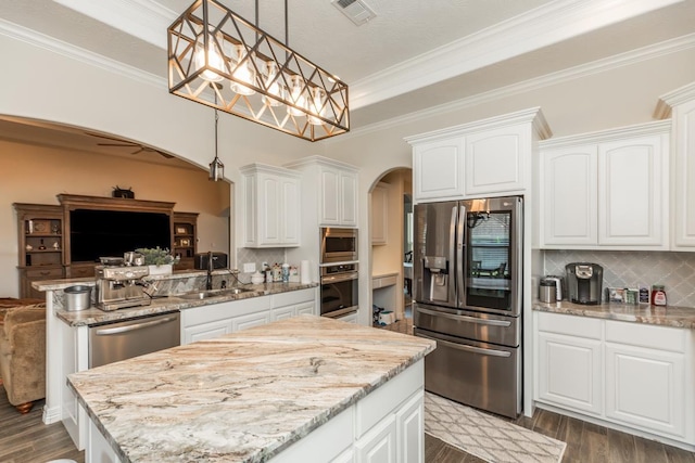 kitchen featuring white cabinets, pendant lighting, backsplash, and stainless steel appliances