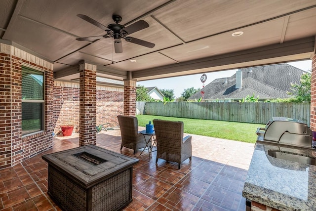 view of patio with area for grilling, an outdoor fire pit, and ceiling fan