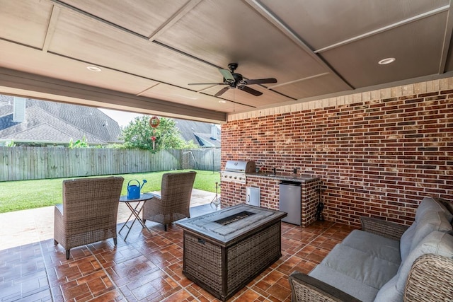 view of patio / terrace with grilling area, ceiling fan, an outdoor living space with a fire pit, and an outdoor kitchen