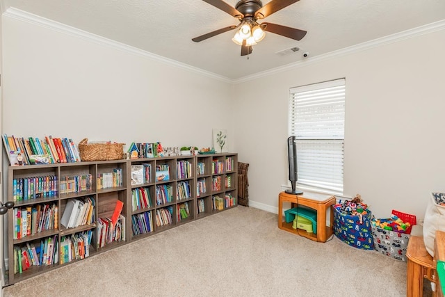 playroom with ceiling fan, carpet floors, and crown molding