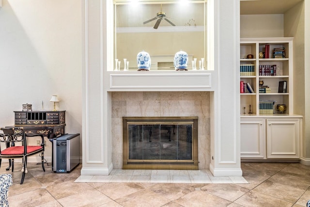 living room with a tile fireplace, ceiling fan, and light tile patterned flooring