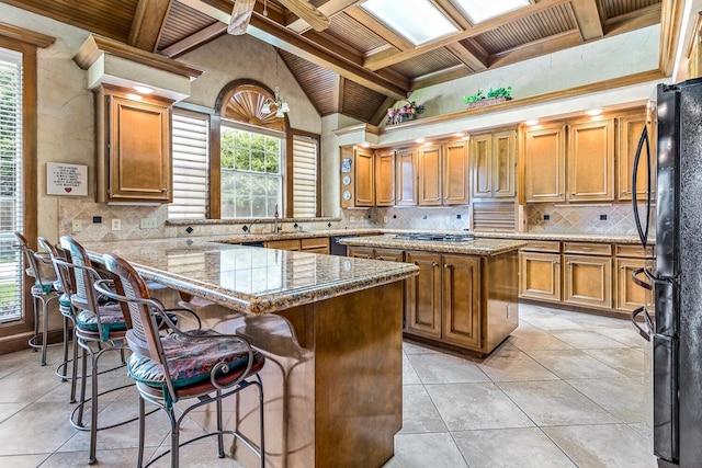 kitchen with decorative backsplash, a center island, wooden ceiling, and coffered ceiling