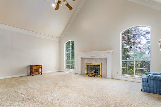 unfurnished living room with carpet, ornamental molding, ceiling fan, high vaulted ceiling, and a tiled fireplace