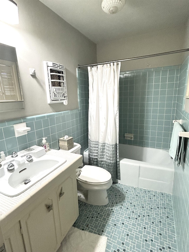 full bathroom with tile patterned floors, tile walls, toilet, vanity, and shower / tub combo