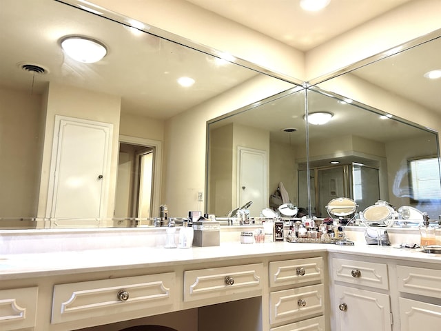 bathroom with vanity and a shower with door