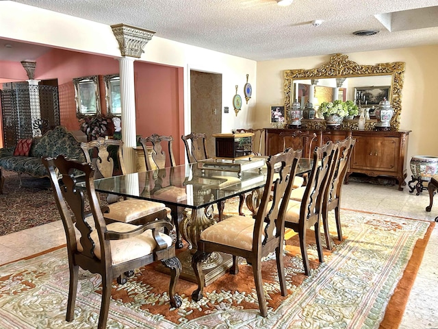 dining area featuring a textured ceiling and decorative columns