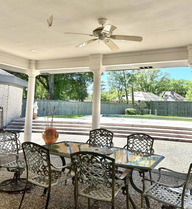 sunroom featuring ornate columns and ceiling fan