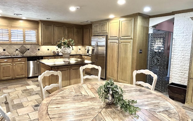 kitchen featuring a breakfast bar, a center island, sink, tasteful backsplash, and stainless steel appliances