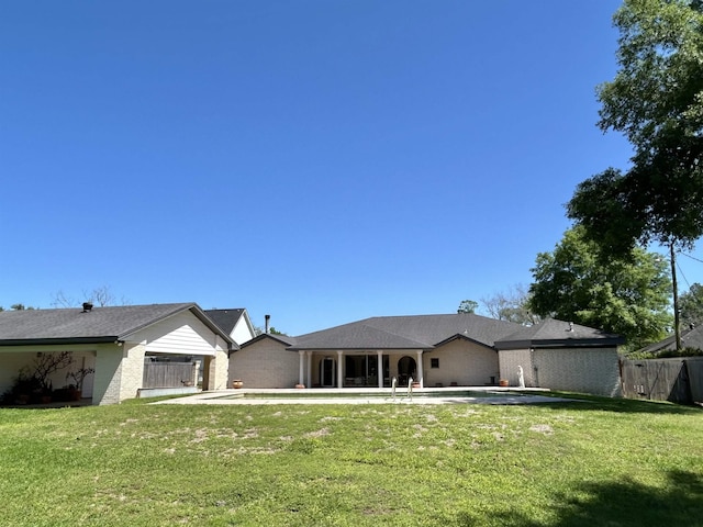 rear view of house featuring a patio area and a yard