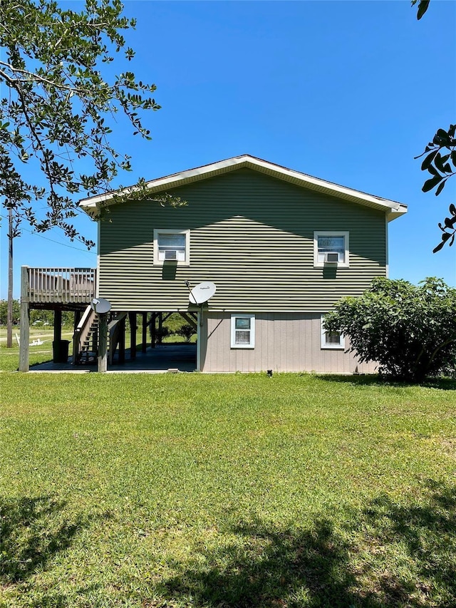 1228 Bahama Ln, Port Bolivar, TX 77650 - view of home's exterior featuring a carport, a yard, a wooden deck, and stairway