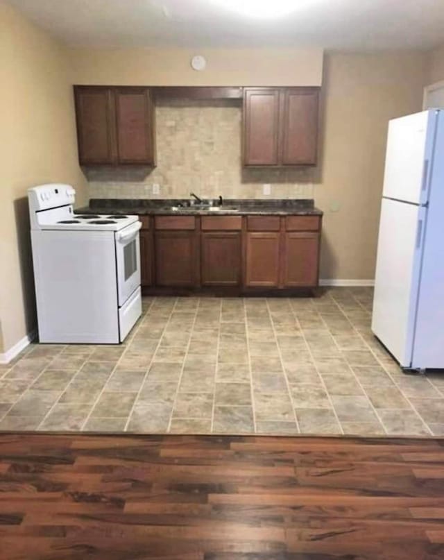 434 US Highway 96, Buna, TX 77612 - kitchen featuring white appliances, dark countertops, light wood-style flooring, and a sink