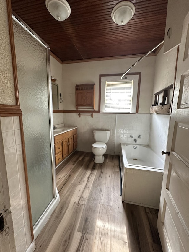 full bathroom featuring independent shower and bath, wood-type flooring, vanity, and toilet