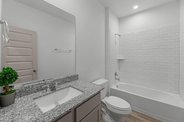 full bath featuring toilet,  shower combination, vanity, and wood finished floors