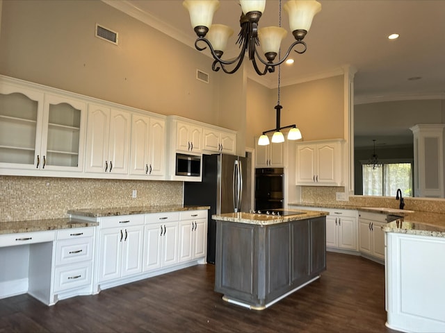 kitchen featuring white cabinetry, stainless steel appliances, an inviting chandelier, light stone counters, and pendant lighting