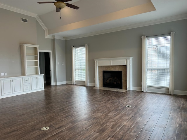 unfurnished living room with a tiled fireplace, ceiling fan, vaulted ceiling, and ornamental molding