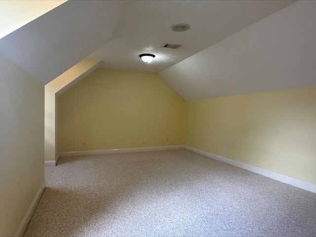 additional living space with carpet flooring and vaulted ceiling