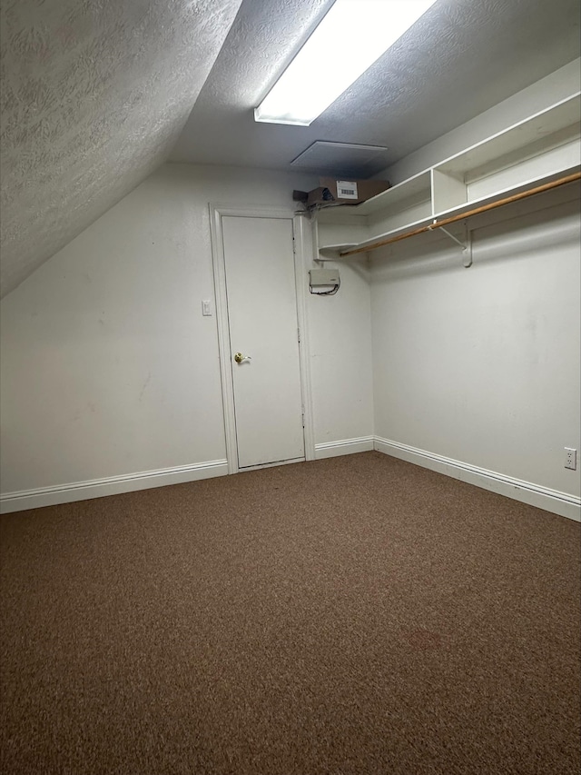 walk in closet featuring carpet floors and vaulted ceiling