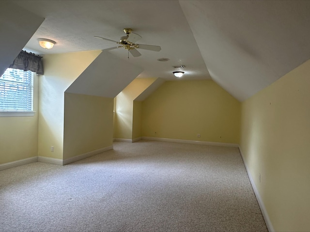 additional living space featuring ceiling fan, light colored carpet, and vaulted ceiling