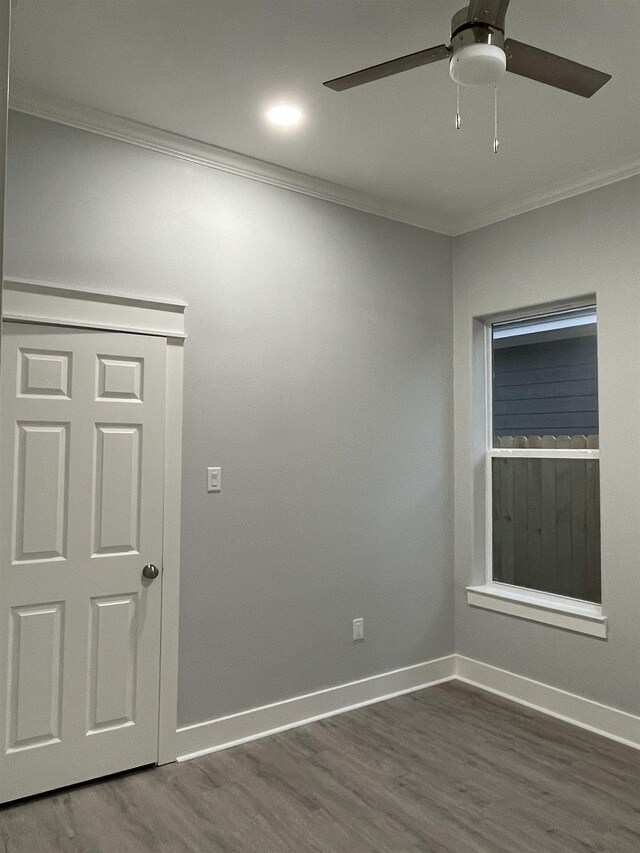 unfurnished room featuring dark wood-type flooring, crown molding, baseboards, and ceiling fan