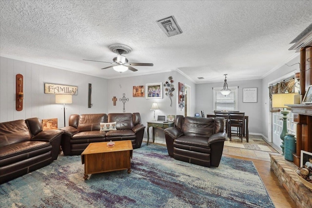 living room with ceiling fan, a textured ceiling, visible vents, crown molding, and baseboards