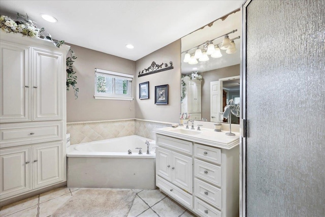 bathroom featuring tile patterned floors, vanity, and a bath