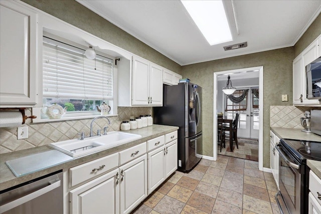 kitchen with appliances with stainless steel finishes, a healthy amount of sunlight, visible vents, and tasteful backsplash