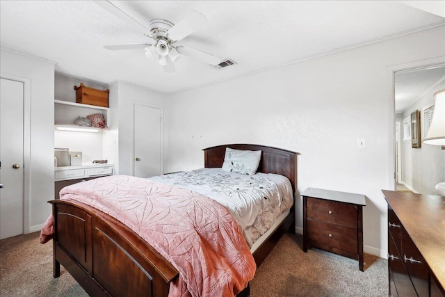 carpeted bedroom with a ceiling fan and visible vents