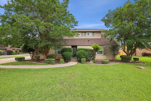 view of front facade with brick siding and a front lawn
