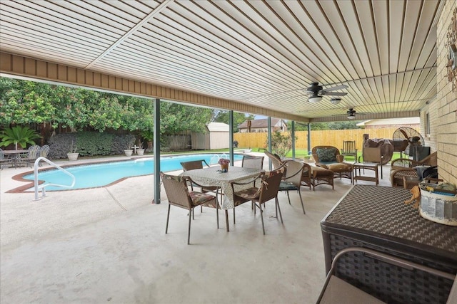 exterior space featuring a patio, outdoor dining area, a fenced backyard, and a storage unit