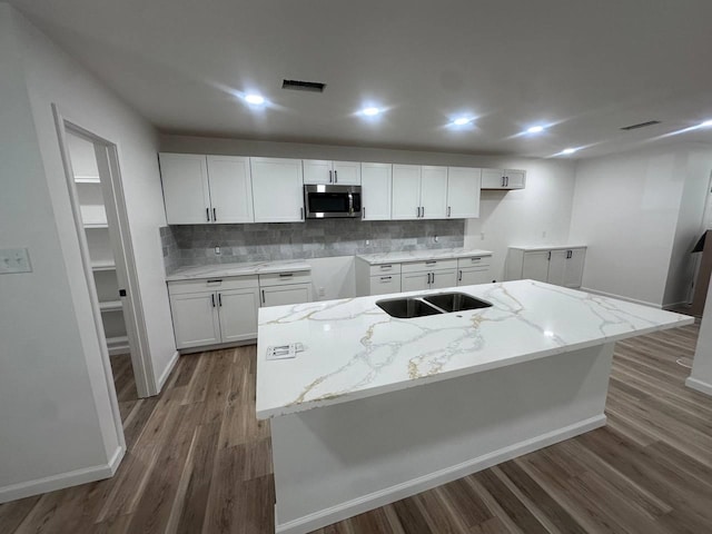 1117 W Dr, Port Neches, TX 77651 - kitchen featuring stainless steel microwave, wood finished floors, backsplash, a sink, and recessed lighting
