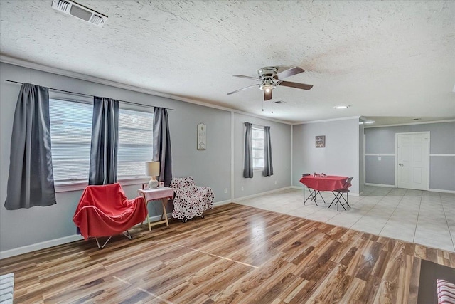 sitting room featuring ceiling fan, a textured ceiling, and light hardwood / wood-style flooring