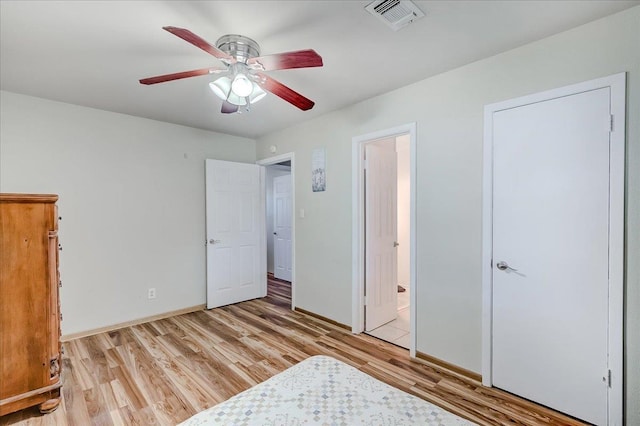 unfurnished bedroom featuring connected bathroom, light hardwood / wood-style floors, and ceiling fan