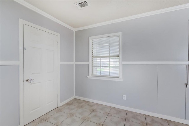 unfurnished room featuring light tile patterned floors and crown molding