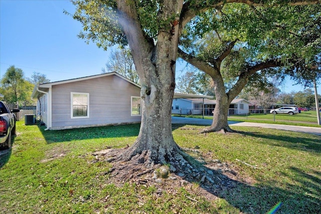 view of property exterior with a yard, cooling unit, and a carport