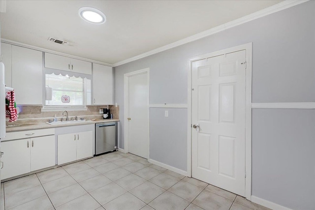 kitchen featuring white cabinets, crown molding, sink, dishwasher, and light tile patterned flooring