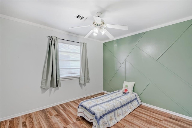 bedroom featuring hardwood / wood-style floors, ceiling fan, and crown molding