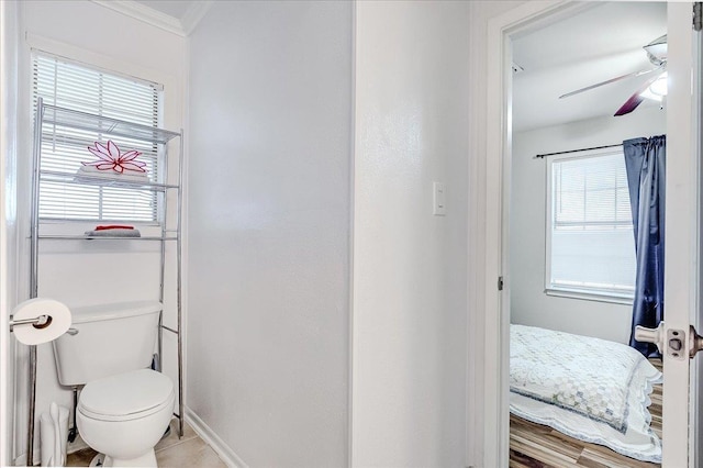 bathroom with toilet, plenty of natural light, ornamental molding, and ceiling fan