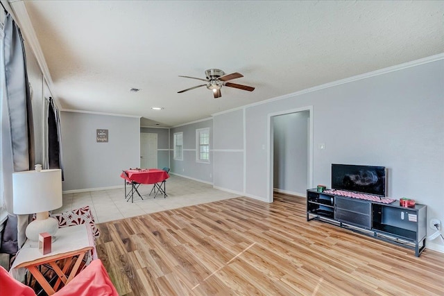 living room with ceiling fan and ornamental molding