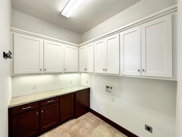 laundry room with electric dryer hookup, cabinet space, hookup for a washing machine, and baseboards