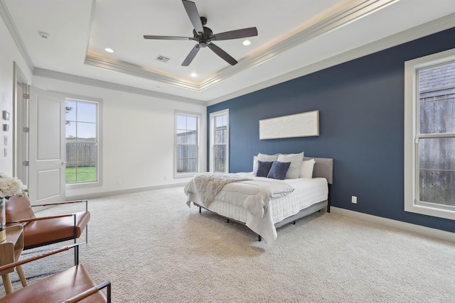 carpeted bedroom featuring a raised ceiling, visible vents, ornamental molding, and baseboards