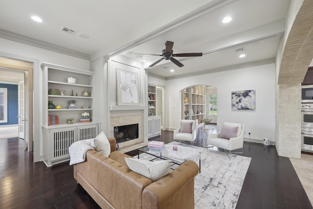 living room with visible vents, arched walkways, wood-type flooring, and crown molding