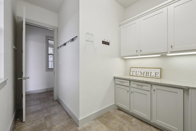 hallway featuring baseboards and light tile patterned floors