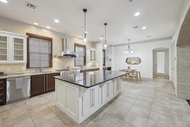 kitchen with a sink, light tile patterned floors, wall chimney exhaust hood, visible vents, and stainless steel dishwasher