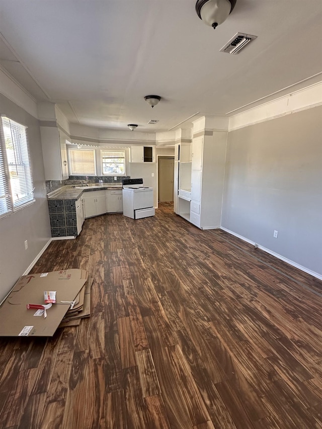 kitchen featuring a healthy amount of sunlight, white cabinetry, dark wood-type flooring, and white electric range