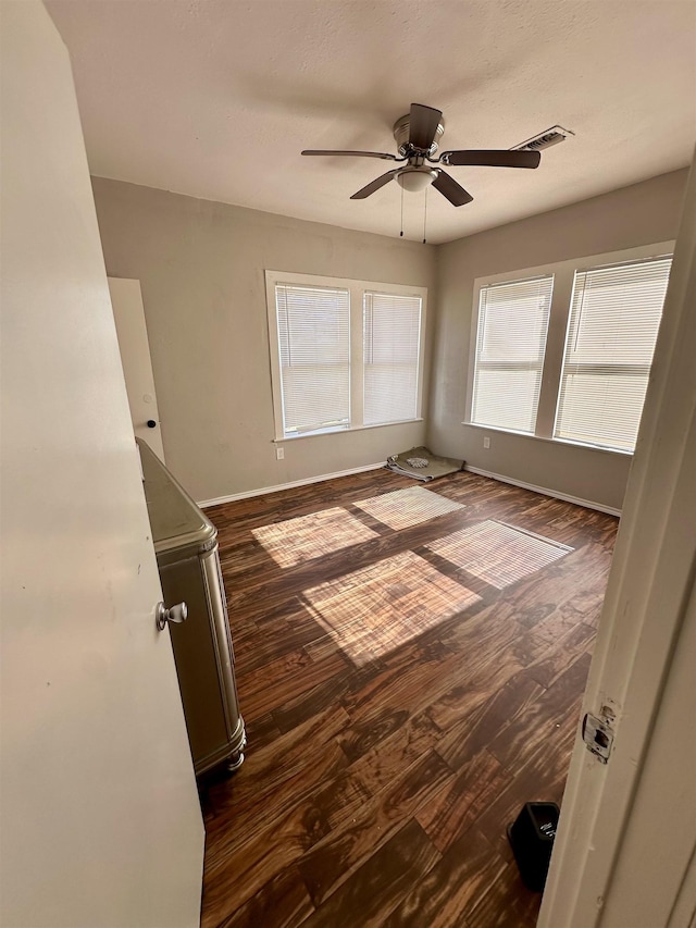 unfurnished room featuring ceiling fan and dark hardwood / wood-style floors