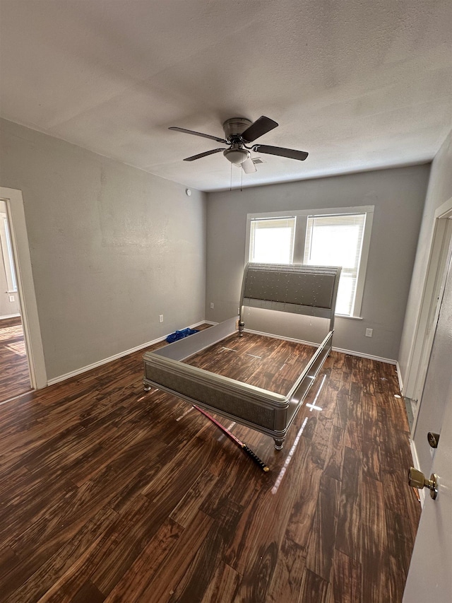 unfurnished bedroom with ceiling fan and dark hardwood / wood-style flooring